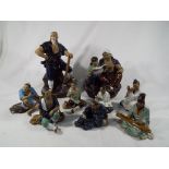 A group of nine figurines depicting Asian figures,