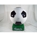 A Carlsberg Soccer Cule beer fridge, portable 240v AC/12, v DC mini chiller / heater HUS - HM5,