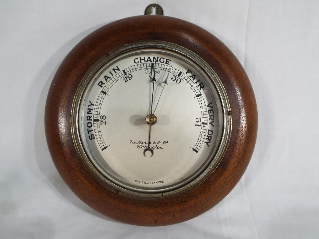 A British made wall mounted round barometer, solid wood surround,