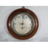 A British made wall mounted round barometer, solid wood surround,