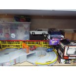 A large quantity of toys to include a Fisher Price racing track, a quantity of playworn cars,