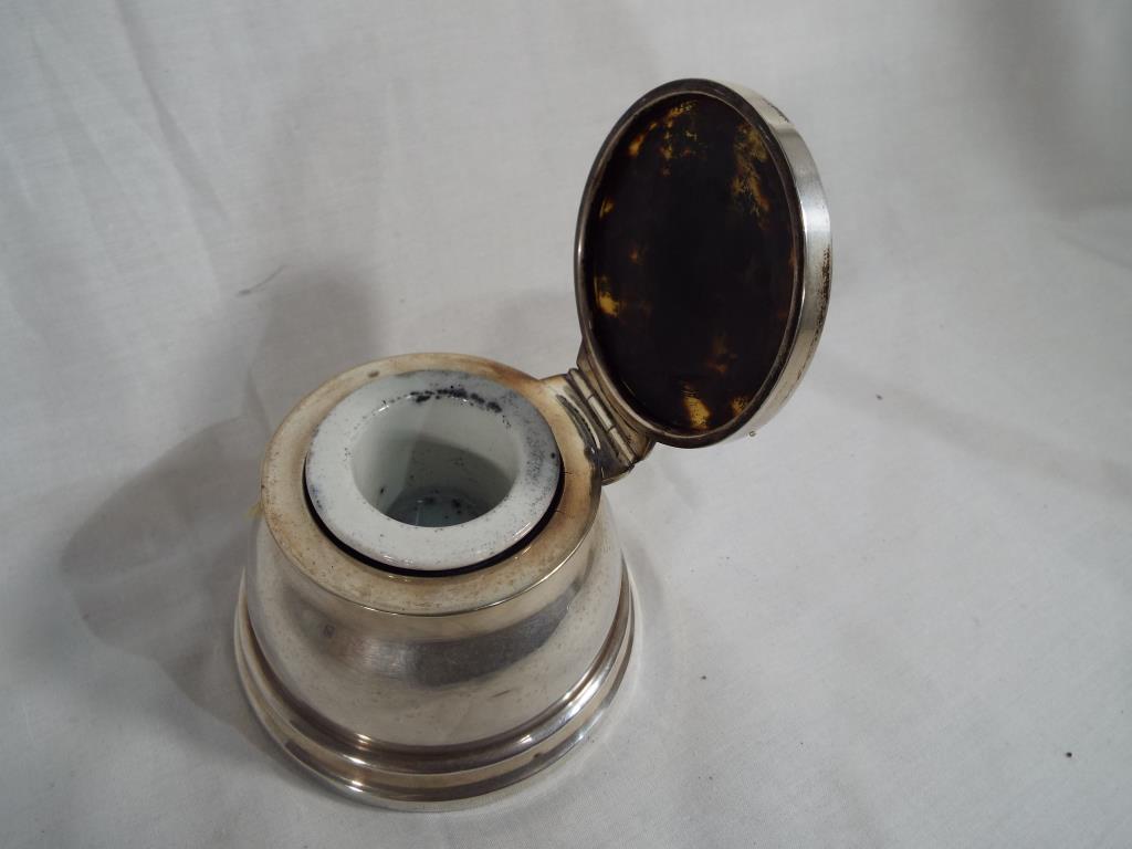 An Edward VII hallmarked silver capstan inkwell with ceramic liner and tortoiseshell lid,