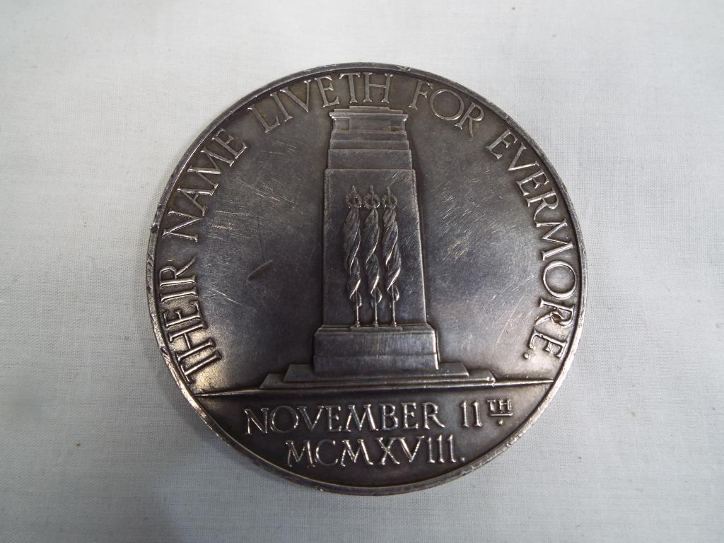 An Armistice Medallion - a white metal 10th Anniversary medallion,
