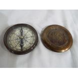 A brass compass with screw release lid,