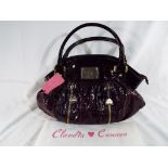 An unused Claudia Canova handbag with tags and clear film covered logo with original dust cover