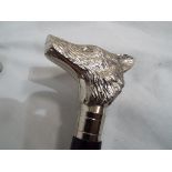 A good quality walking stick with a white metal handle depicting a wolf's head,