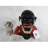 A cast iron novelty money bank in the form of a black man and a good quality white metal Ronson