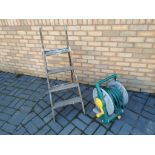 A garden hose reel and a set of vintage step ladders - (2)