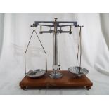 A set of scales by G Oertling Ltd of London on a wooden base 34 cm (h) x 33 cm (w) together with a