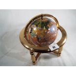 A modern globe in the style of traditional stone globes, 22 cm (h) x 22 cm (d).