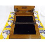 An oak writing slope with fitted interior containing inkwells and blotting paper