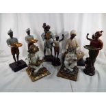 A collection of seven ethnic figurines of men in various poses,