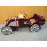 A child's pedal car in the style of a vintage motor car, unused,