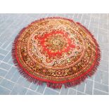 A good circular rug of typical form, red ground,