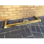 A brass extending hearth fender