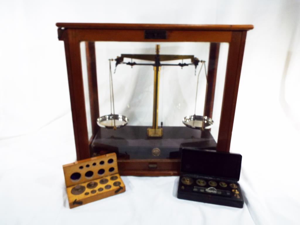 A scientific weighing balance with two boxes of weights, the scales marked Griffin & George Ltd,