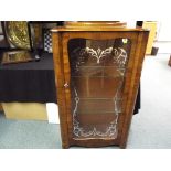 An early 20th century display cabinet with a glazed door,