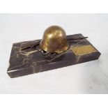 A memorial plaque with German helmet and rifle on marble base, 6.5 cm (h) x 14.8 cm (w) x 6.