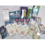 A small collection of uncirculated UK commemorative coins in presentation wallets,