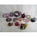 A collection of 13 predominantly glass paperweights to include a Medina glass dome paperweight,