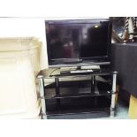 A Sony Bravia 26" flat screen TV with remote control and glass stand.