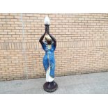 A good quality standard lamp in the form of a life size Egyptian Goddess holding a torch with glass