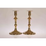 A PAIR OF GEORGIAN BRASS PETAL BASE CANDLESTICKS, with knopped stems. 19.