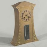 A CONTINENTAL ARTS AND CRAFTS HAMMERED BRASS MANTEL CLOCK, the tall case decorated with bosses,