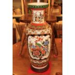 Oriental pottery vase with bird and floral decoration on wooden stand