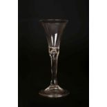 AN 18TH CENTURY WINE GLASS, with trumpet shaped bowl and tear drop stem, on a folded foot.