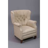 A 19TH CENTURY DEEP BUTTONED ARMCHAIR, with beech frame and hooped back.