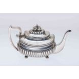 A GEORGE III SILVER TEAPOT, London 1810, with gadrooned edges and partially reeded body,