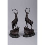 AFTER MOIGNIEZ, A LARGE PAIR OF BRONZE STAGS, each beast cast standing on a rocky outcrop,