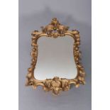 A 19TH CENTURY GILT COMPOSITION MIRROR IN ROCOCO STYLE, boldly moulded with scrolls and acanthus.