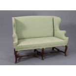 A 19TH CENTURY WALNUT AND UPHOLSTERED SETTEE IN QUEEN ANNE STYLE, with wingback and scroll arms,