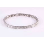 A DIAMOND BANGLE, of flexible form,