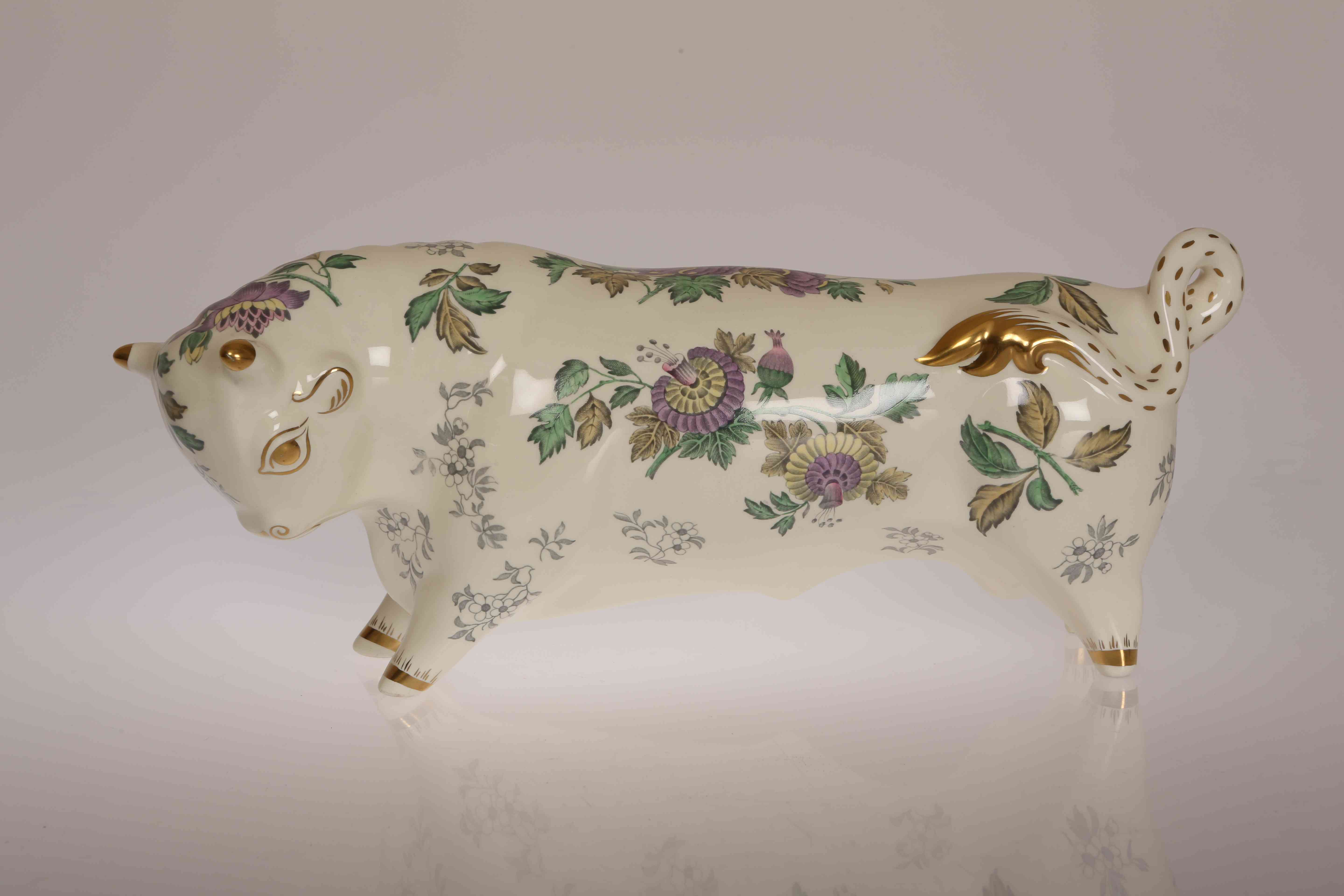 A WEDGWOOD MODEL OF A BULL, designed by Arnold Machin and decorated with flowers and foliage,