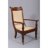 A COLONIAL 19TH CENTURY TEAK PLANTERS CHAIR, the crest rail centred by a wheatsheaf,