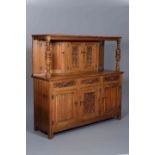 A LARGE OAK COURT CUPBOARD, the upper section with carved panel doors and cup and cover columns,