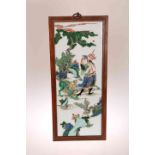 A CHINESE FAMILLE VERTE PORCELAIN PANEL, enamel painted with a dragon and a man, in a wooden frame.