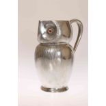 A LIBERTY & CO ENGLISH PEWTER "OWL" JUG, cast in the form of an owl with glass eyes, no.