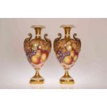 A PAIR OF ROYAL WORCESTER FRUIT PAINTED VASES, the two-handled pedestal bodies painted with apples,