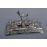 A VICTORIAN SILVER PLATE DESK STAND, surmounted by the figure of a goat and engraved with ferns,