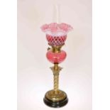 A VICTORIAN BRASS AND CRANBERRY GLASS OIL LAMP,