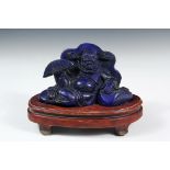 CHINESE HARDSTONE CARVING - Lapis Lazuli Figure of a Reclining Manchurian Scholar in distinctive '