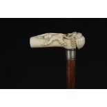 NOVELTY HANDLED CANE - 19th c Malacca Wood Cane with a Carved Handle depicting a boy in a Pierrot