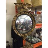 Regency style gilt convex wall mirror surmounted with an eagle.