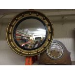 A circular gilt framed porthole mirror and an oak mantel clock