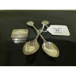 A pair of silver teaspoons together with a small silver pill box.