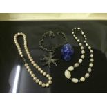 A filigree necklace, together with two faux pearl necklaces and lapis Lazuli skull.